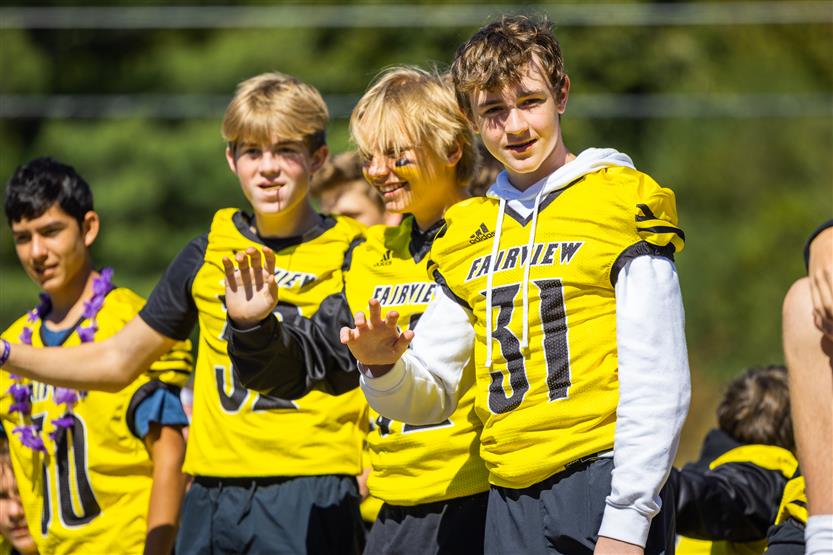 Three football players smile